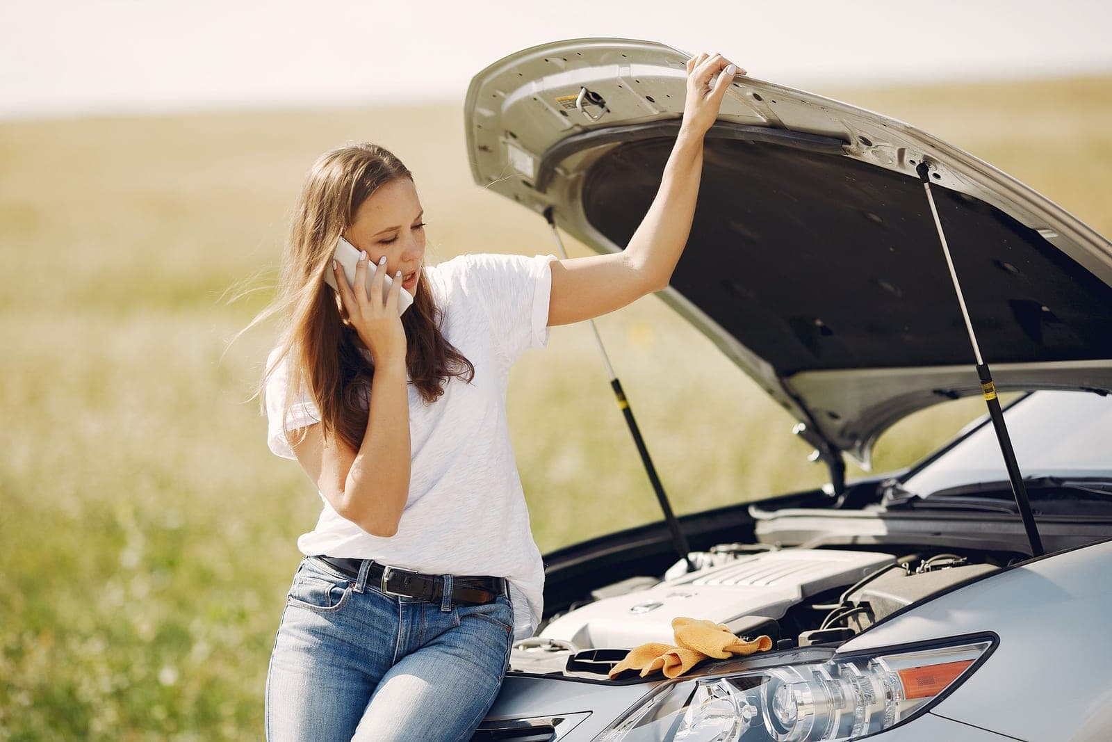 A car stopped at the roadside in open country with the hood up