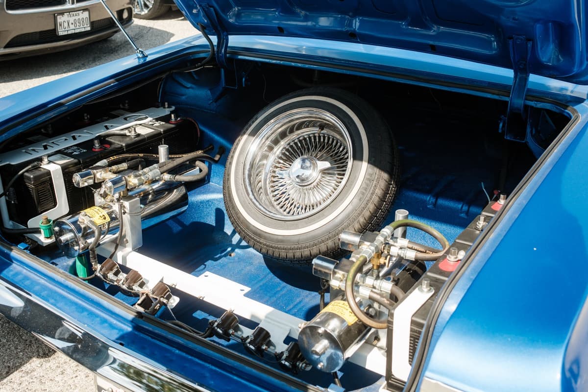 The open trunk of a car holding a spare wheel and gear